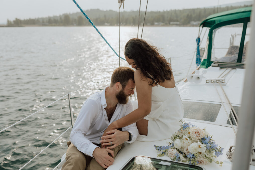 bride and groom on a sailboat laughing together while sitting