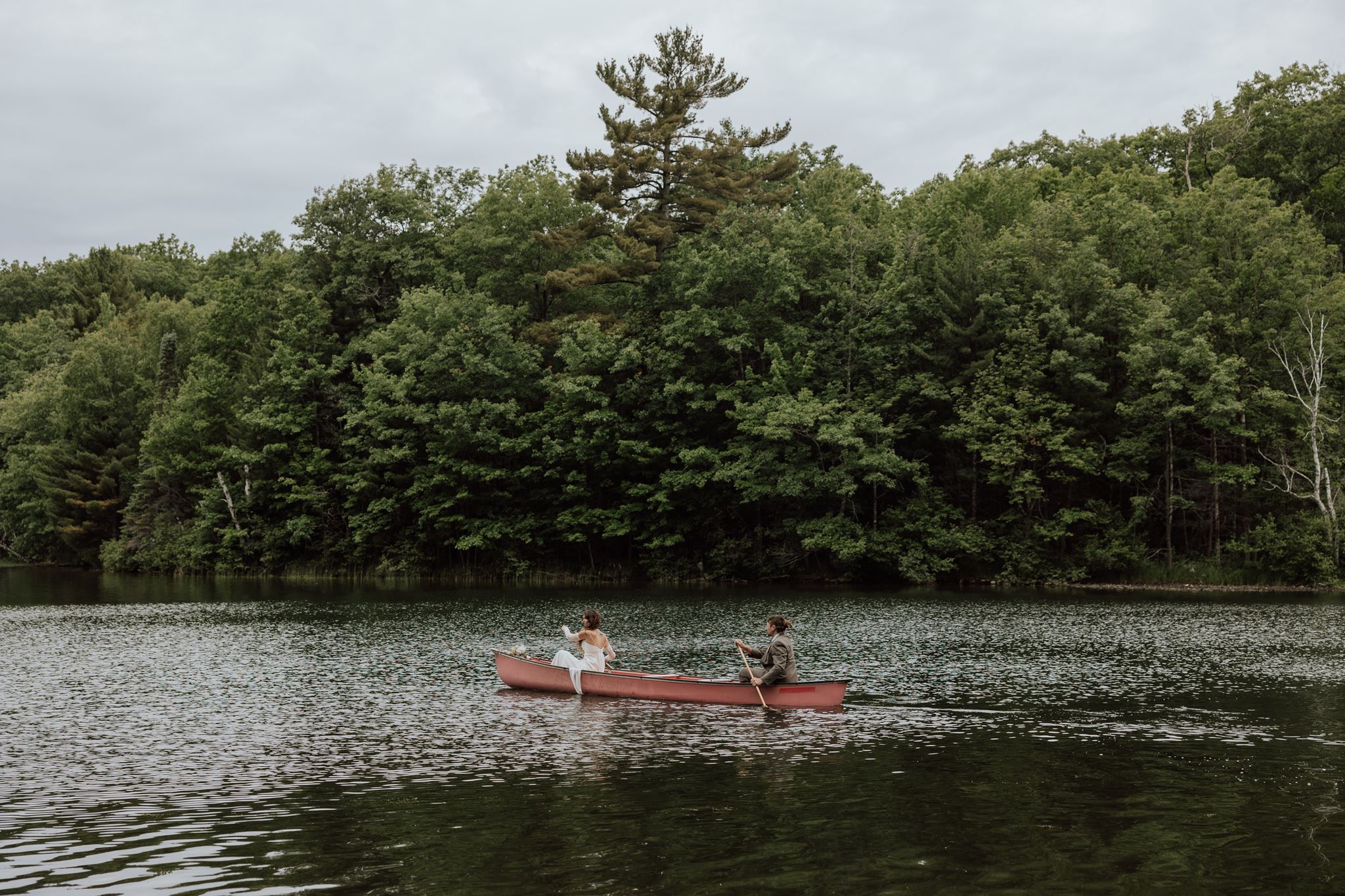 couple canoeing on a northwoods lake for their elopement
