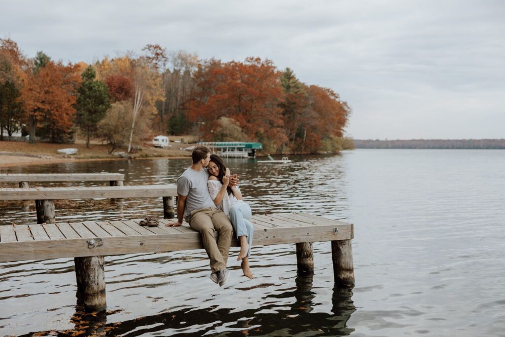 couple sitting on a dock on a northwoods lake